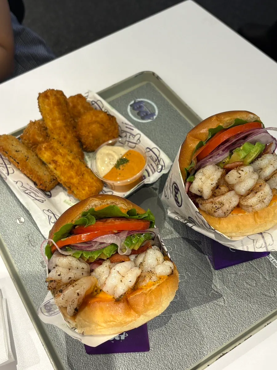 A bite of burger showing avocado and shrimp together