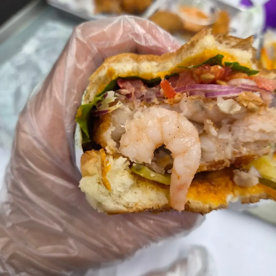 A bite of the shrimp burger showing the thick patty