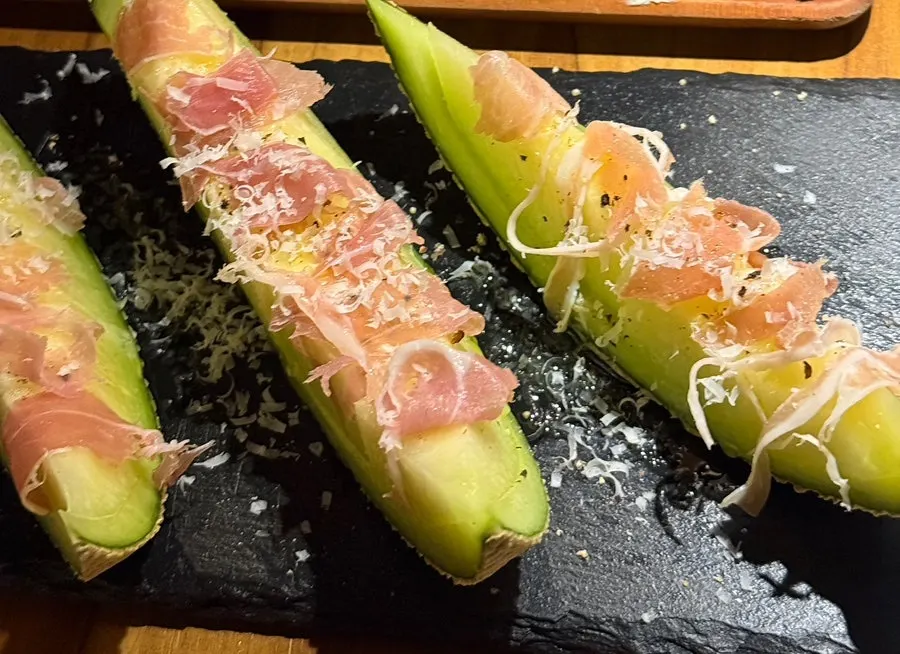 Close-up of melon prosciutto sprinkled with cheese powder