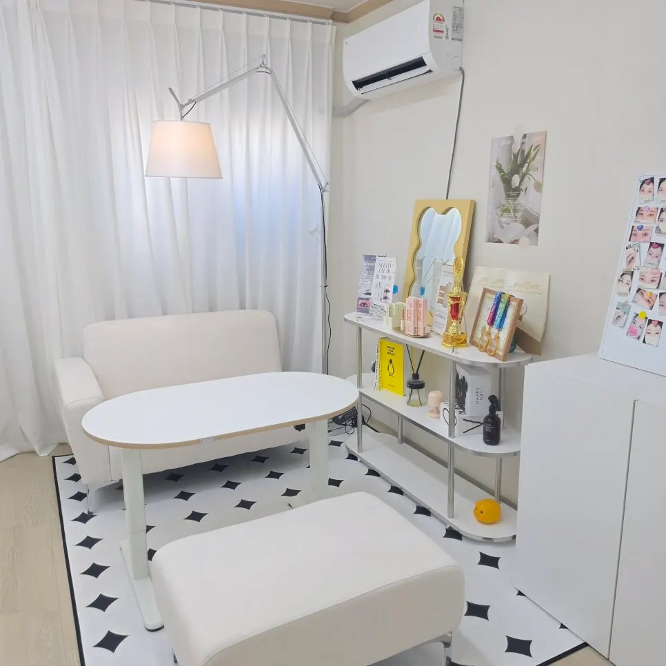 Beauty Haze waiting area with a white-toned sofa and standing lamp