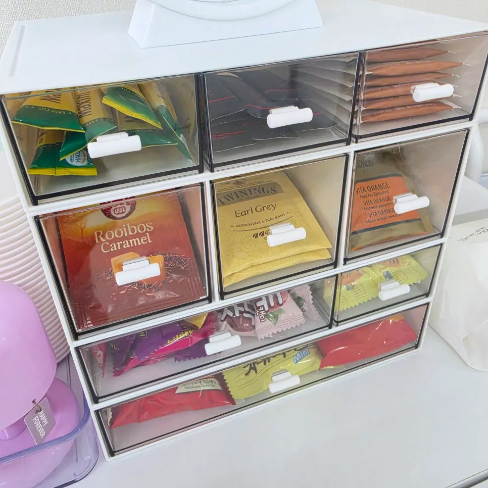 Assorted tea bags and snacks displayed in a drawer