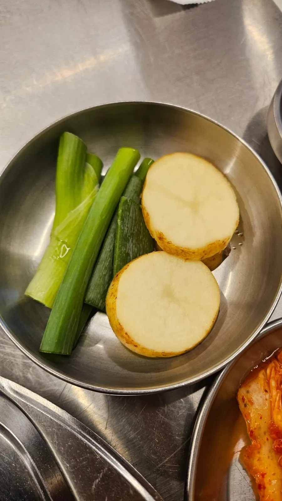 Sliced potato and green onion grilled on the pan