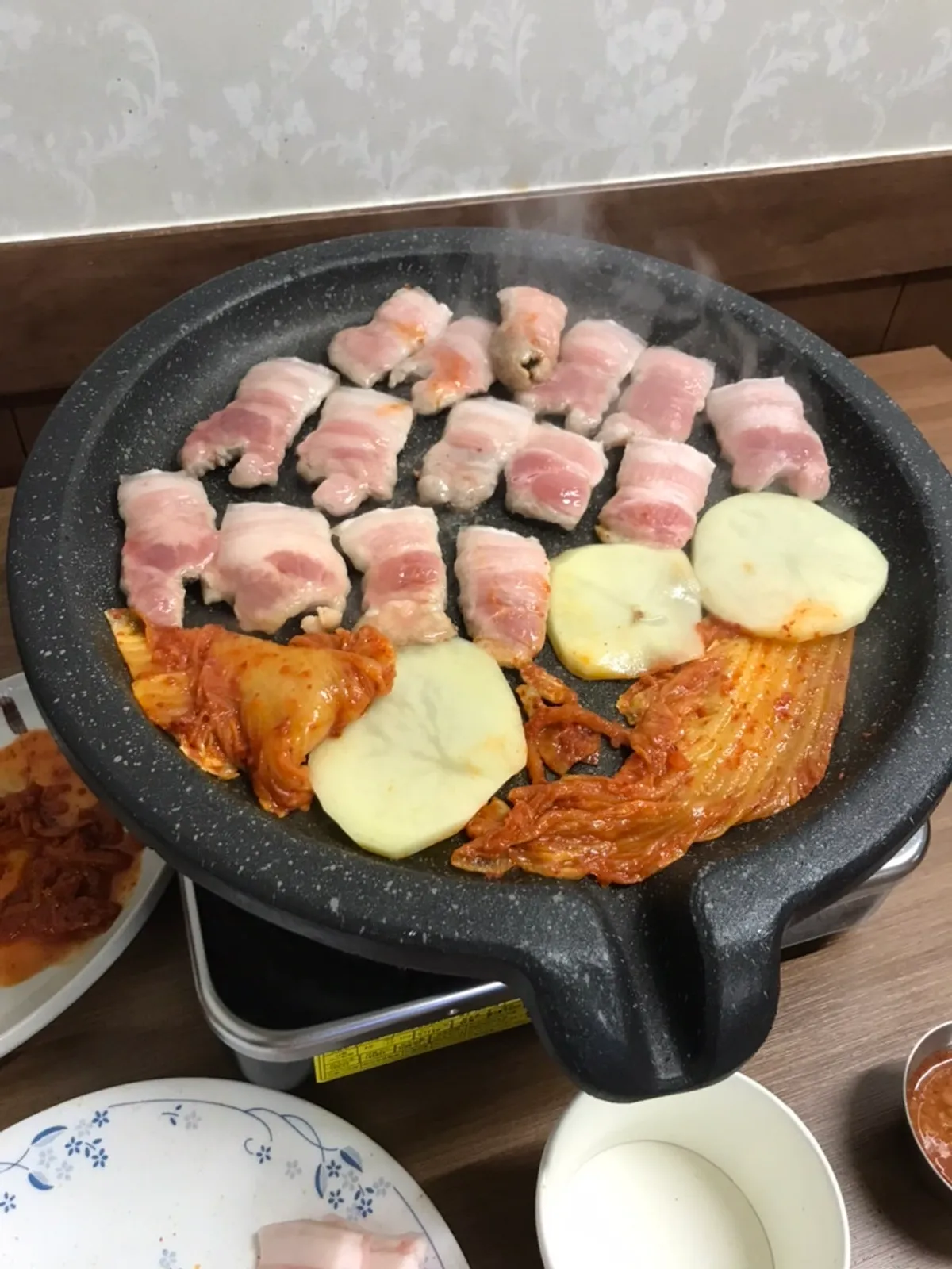 Teuk-ogyeopsal placed on the burner grill plate