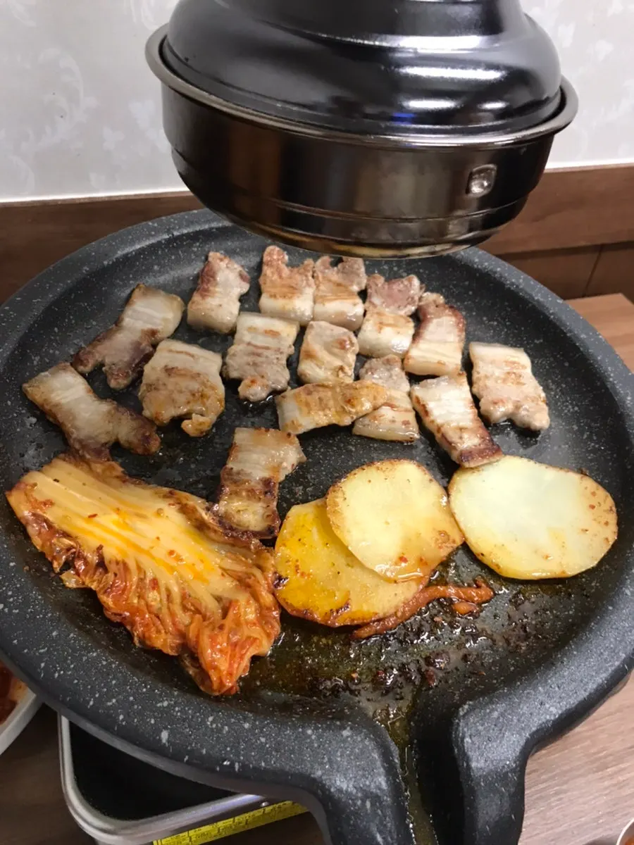 Potatoes, mushrooms, and stir-fried kimchi placed at the bottom of the grill plate