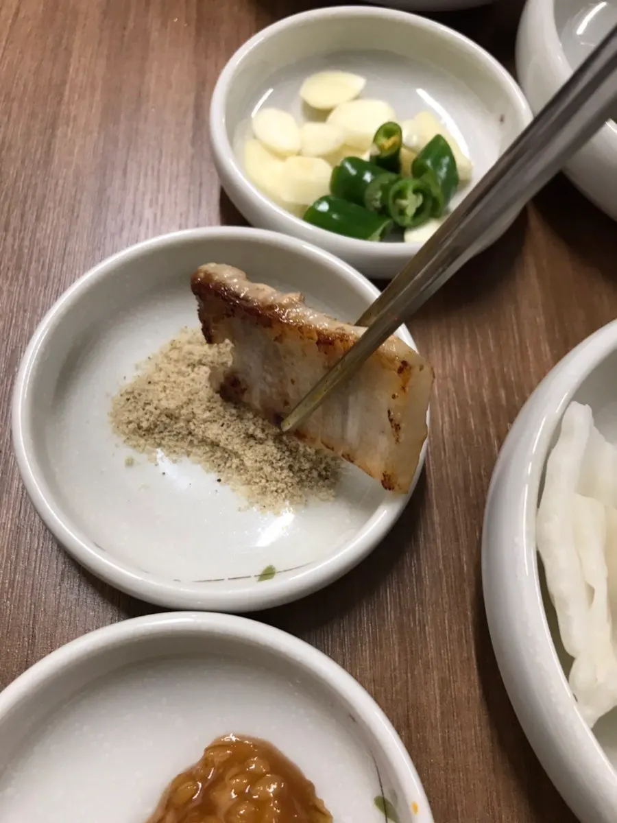 Golden, well-cooked pork belly with a glass of somaek