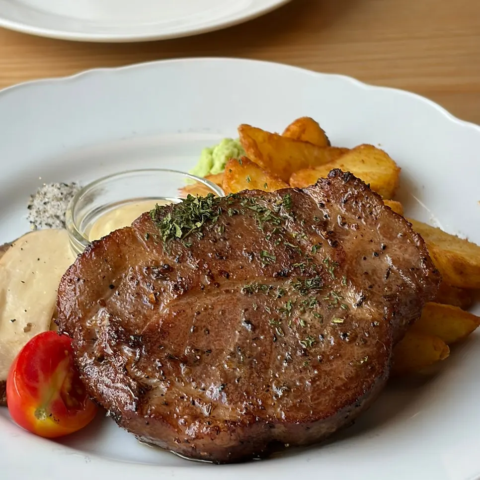 Pork neck steak with garnishes