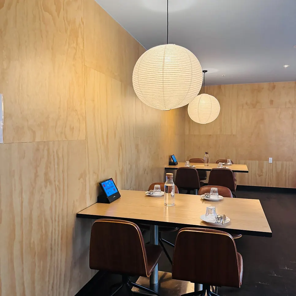 Seating toward the back of the restaurant with a glass-block wall