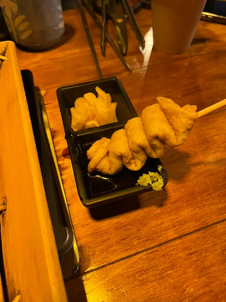 Fish cake dipped in wasabi soy sauce