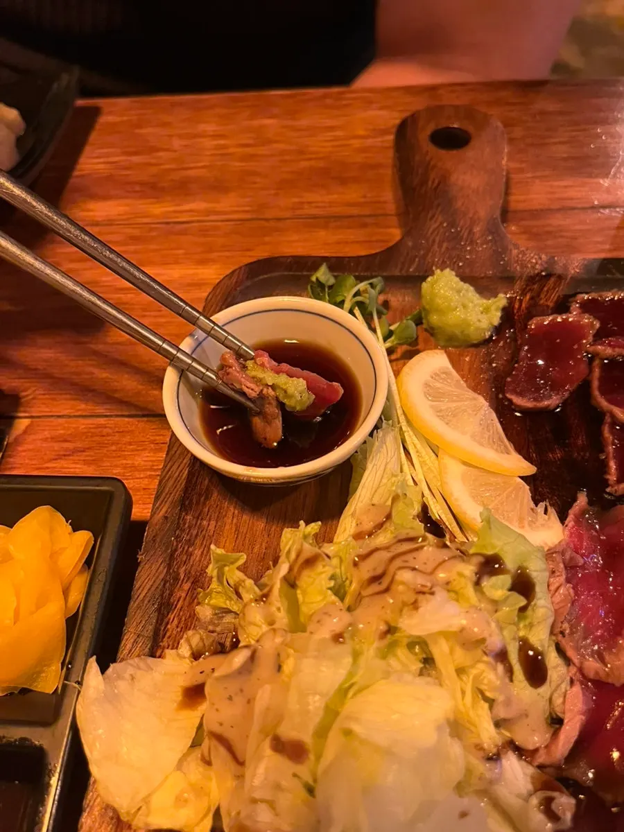 A slice of beef tataki topped with wasabi