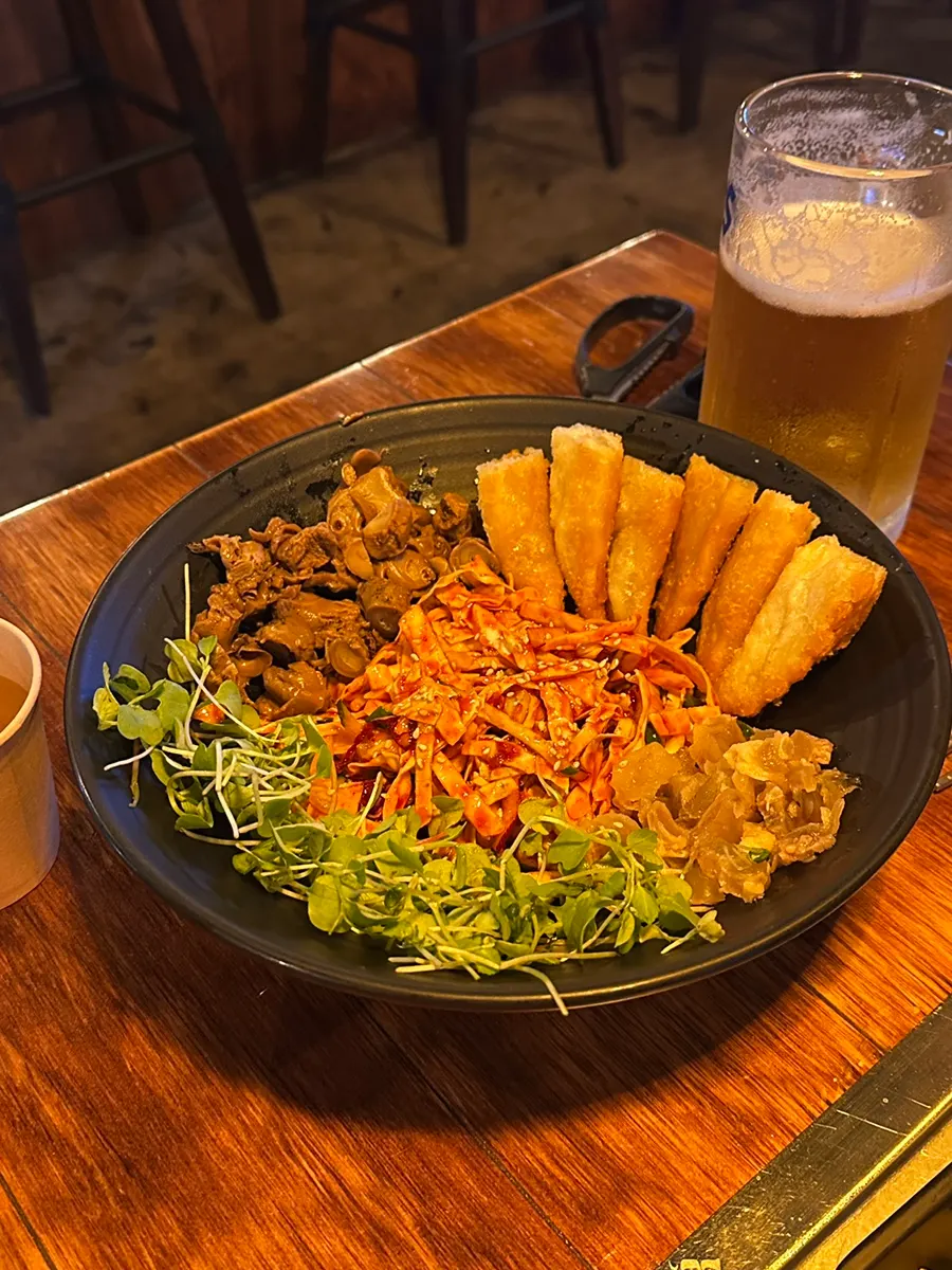 A tofu pouch lifted out with tongs
