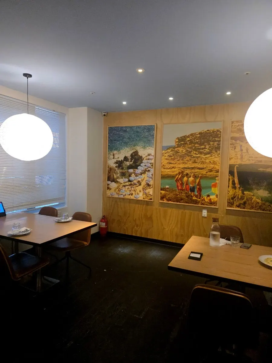 Wall hung with paintings, gallery-café style