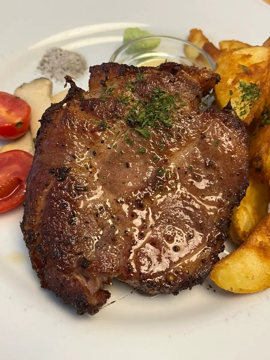 Sous-vide pork neck with wedge fries and roasted vegetables