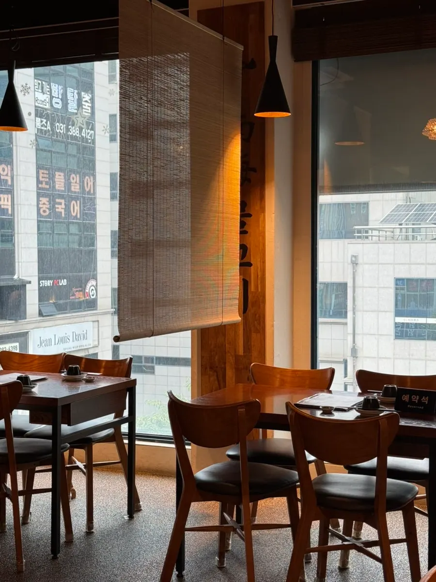Wood-toned interior with bamboo blind-screened seating