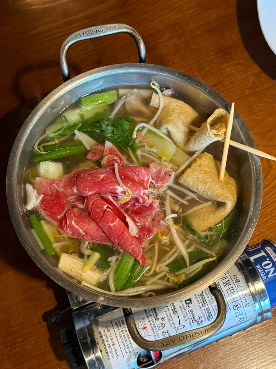 Shabu-shabu spread with vegetables, fish cake, and beef