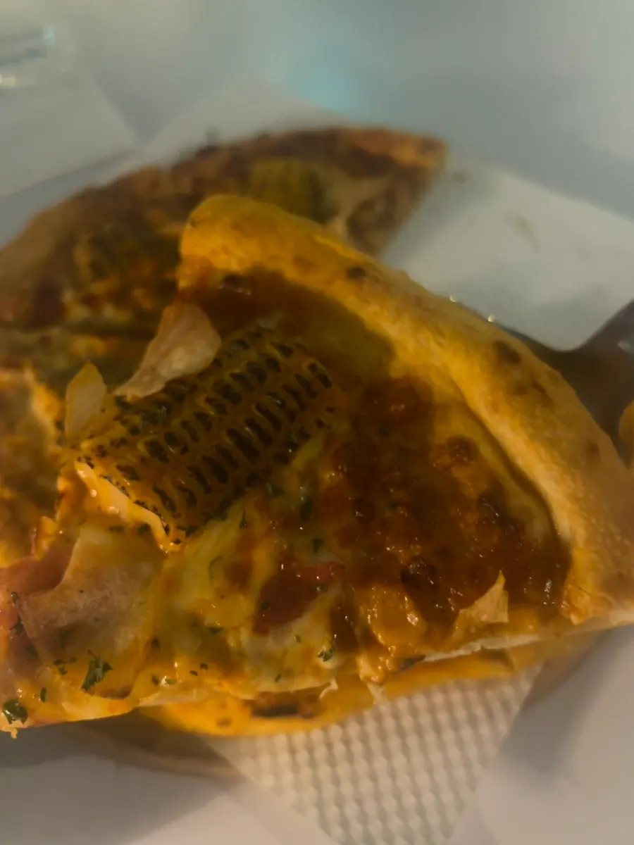 A slice of corn pizza lifted up