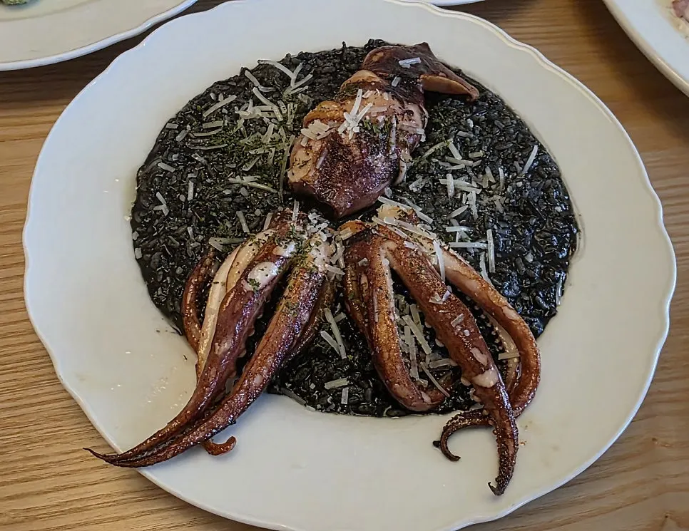 Squid ink risotto topped with whole squid