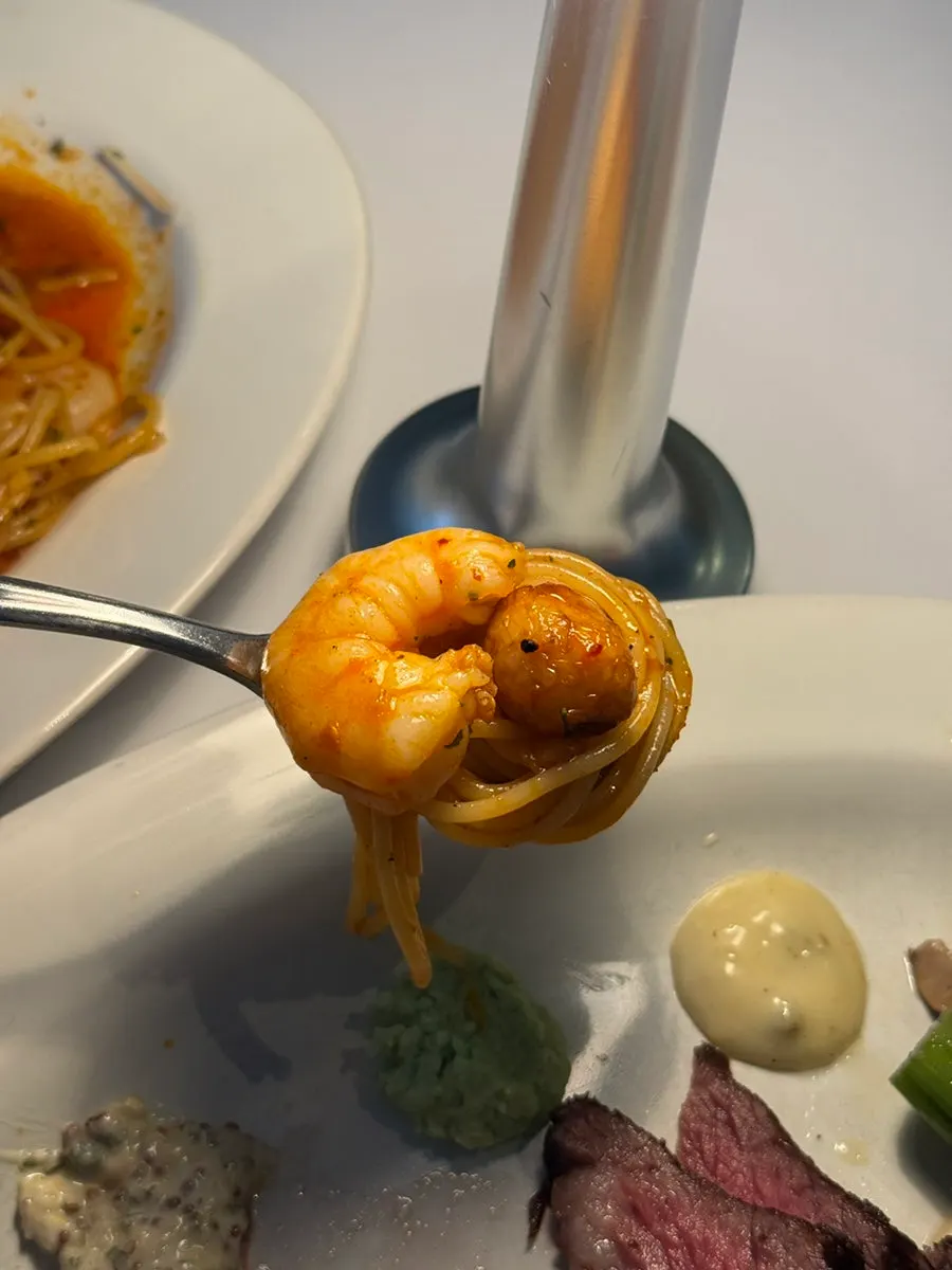 Pasta forkful with shrimp and a whole garlic clove