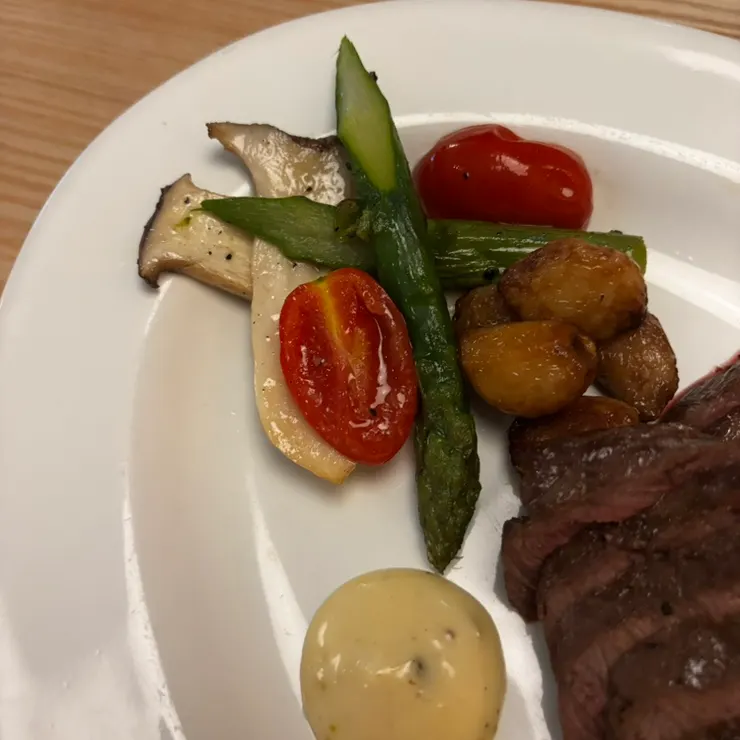 스테이크에 곁들여진 구운 버섯과 토마토, 마늘