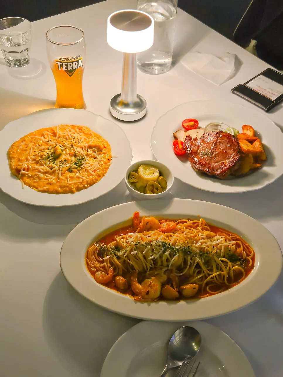 Table set with pasta, risotto, and steak