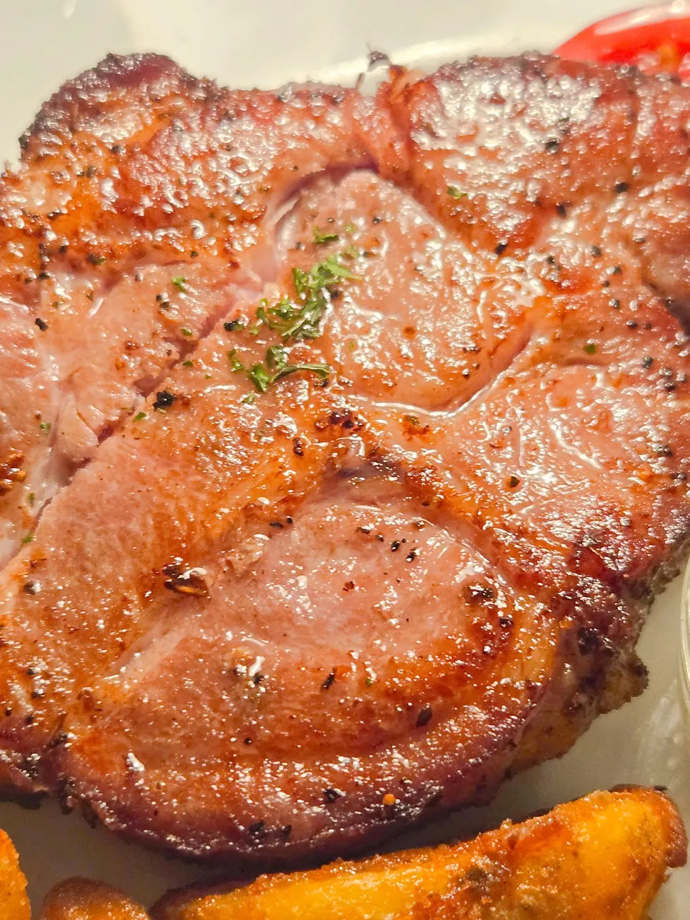 Sous-vide pork neck steak with wedge potatoes and garnish