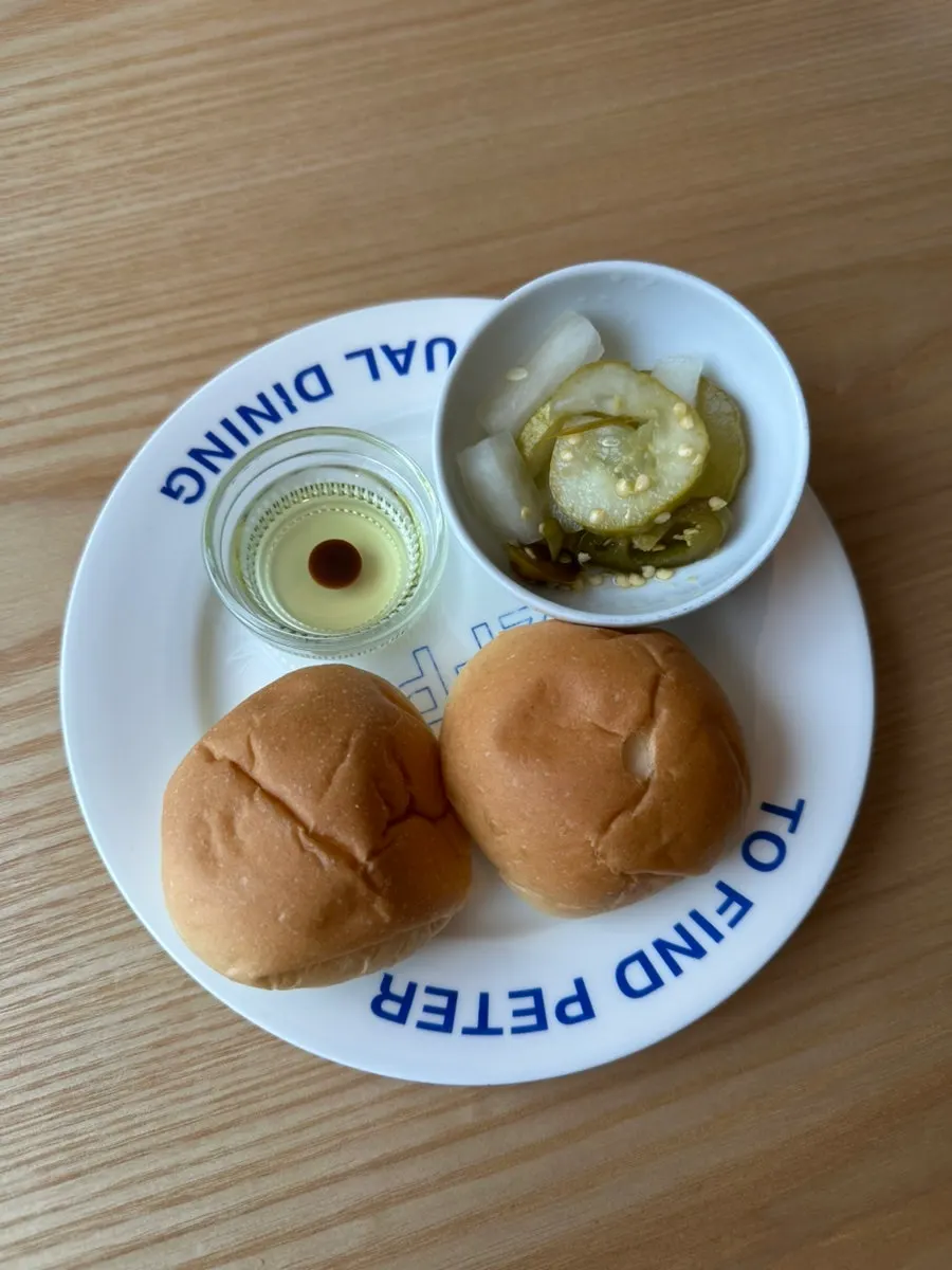 Warm dinner rolls and cucumber pickles served before the meal