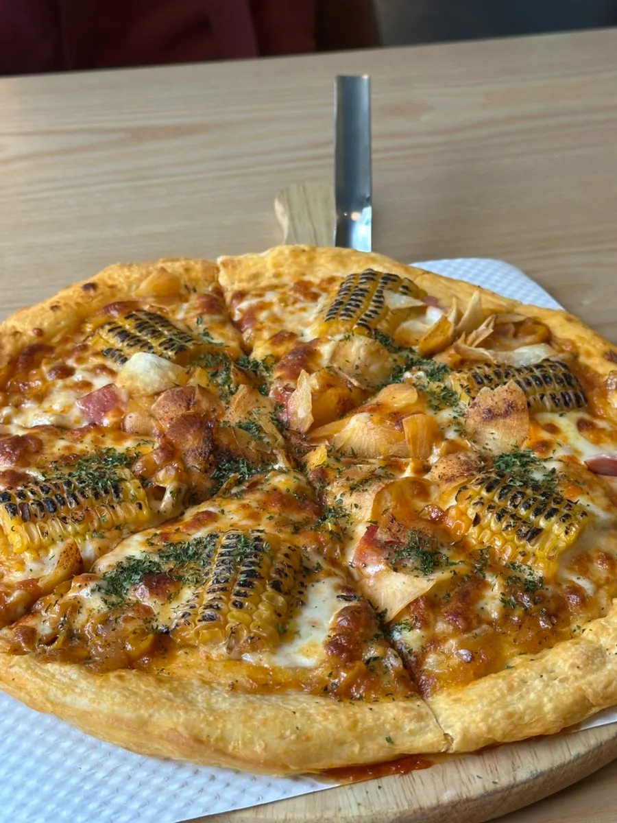 Cross-section of corn pizza with stretchy cheese