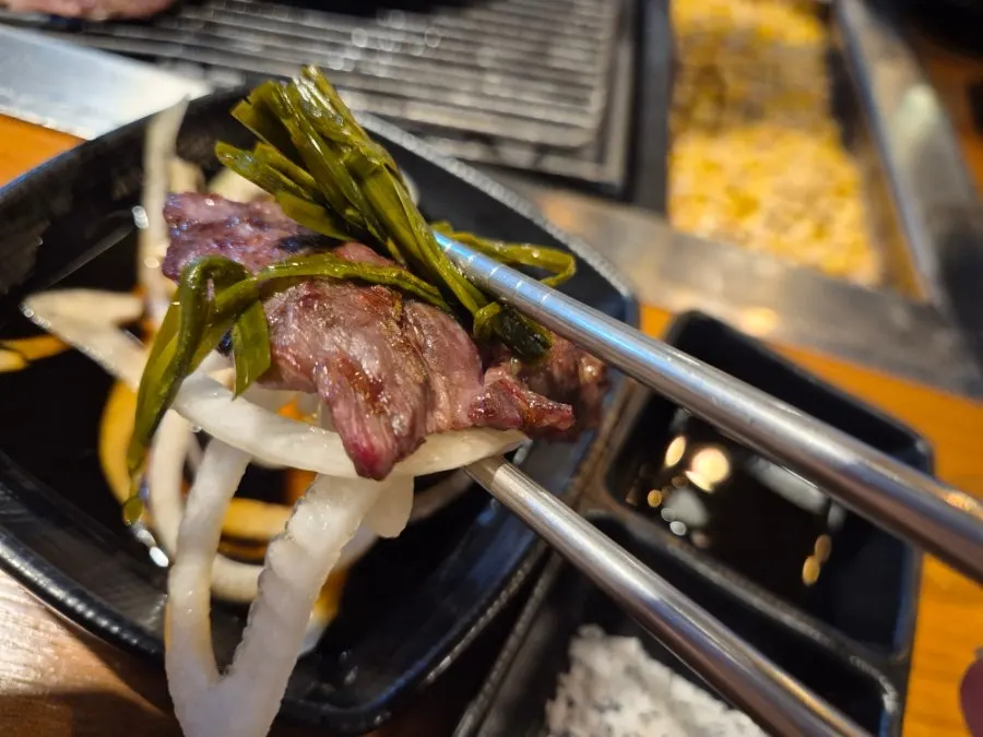 A piece of Korean beef dwitgogi grilled over charcoal