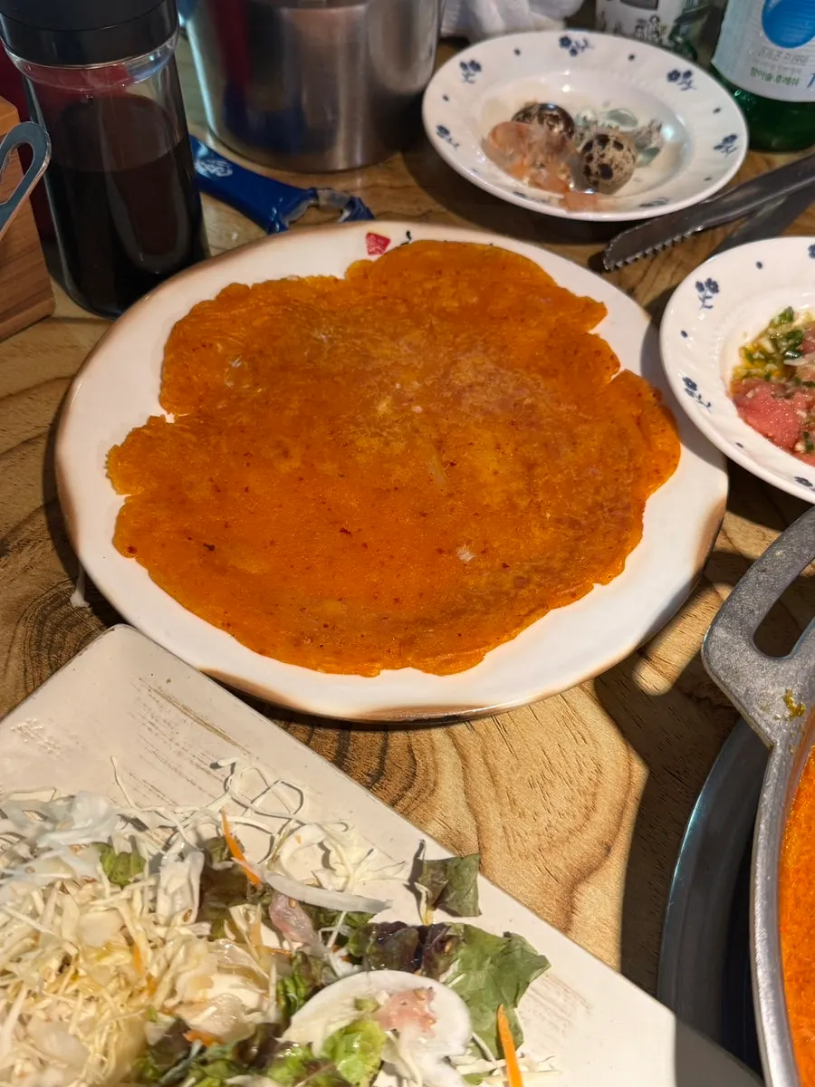 Kimchi jeon batter being hand-fried
