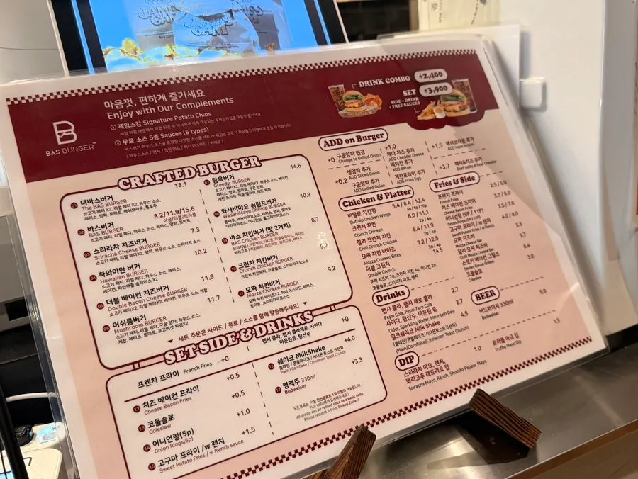 Menu board listing burgers and sides at Base Burger