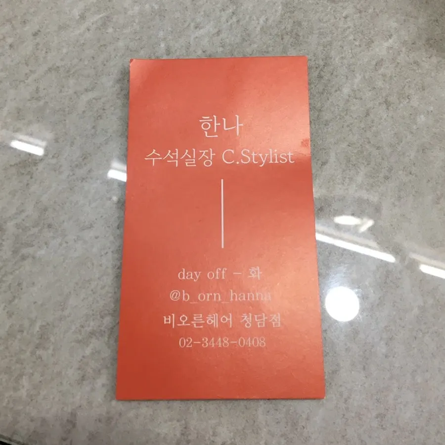Table with the stylist's business card and a drink