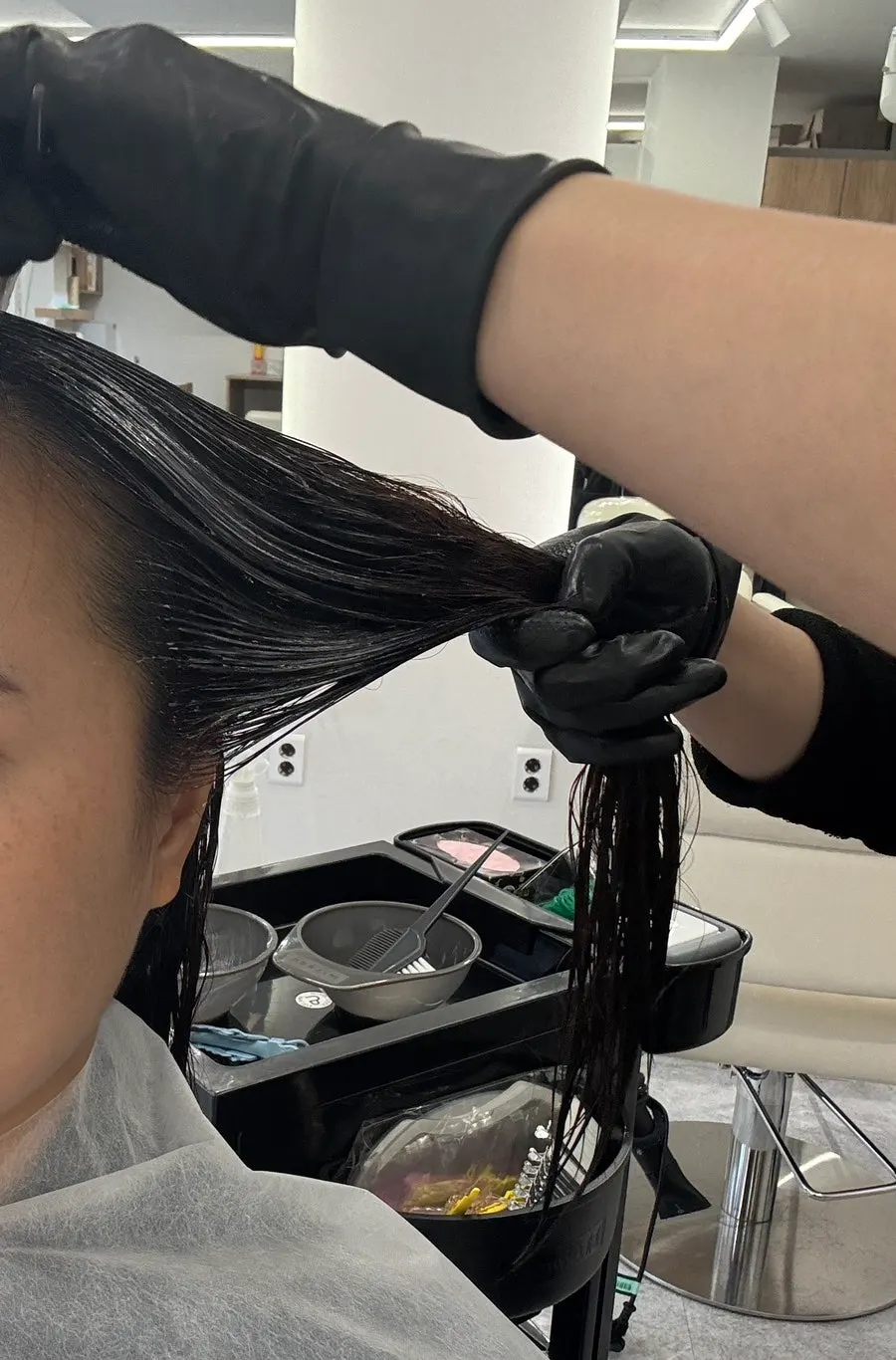 Straightening solution being applied to the hair