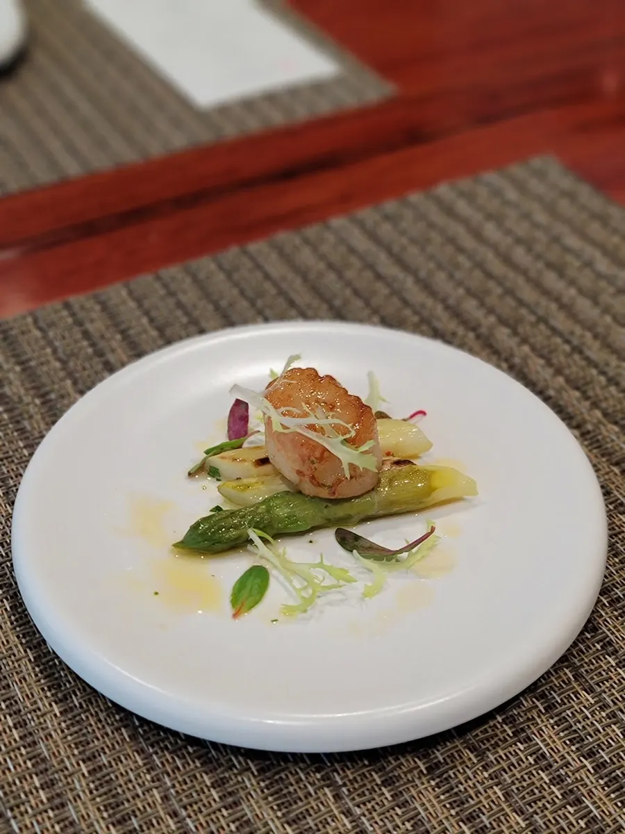 Asparagus with seared scallop served as an appetizer