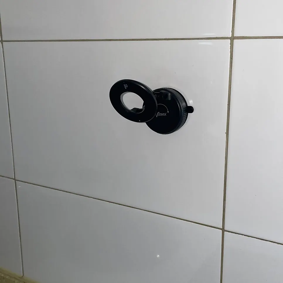 Phone mount suctioned onto kitchen tile