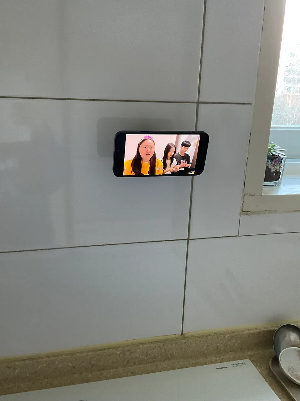 Wall-mounted phone holder used for watching YouTube