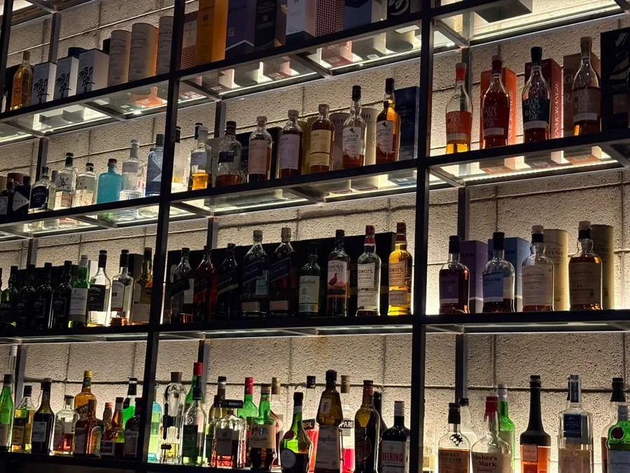 The bar seats at Bitters lined with bottles on display