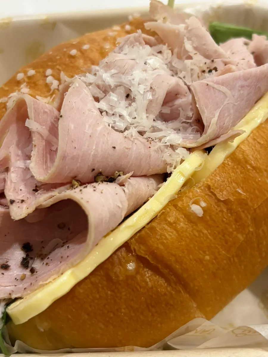 Cross-section of a salt bread sandwich with an americano