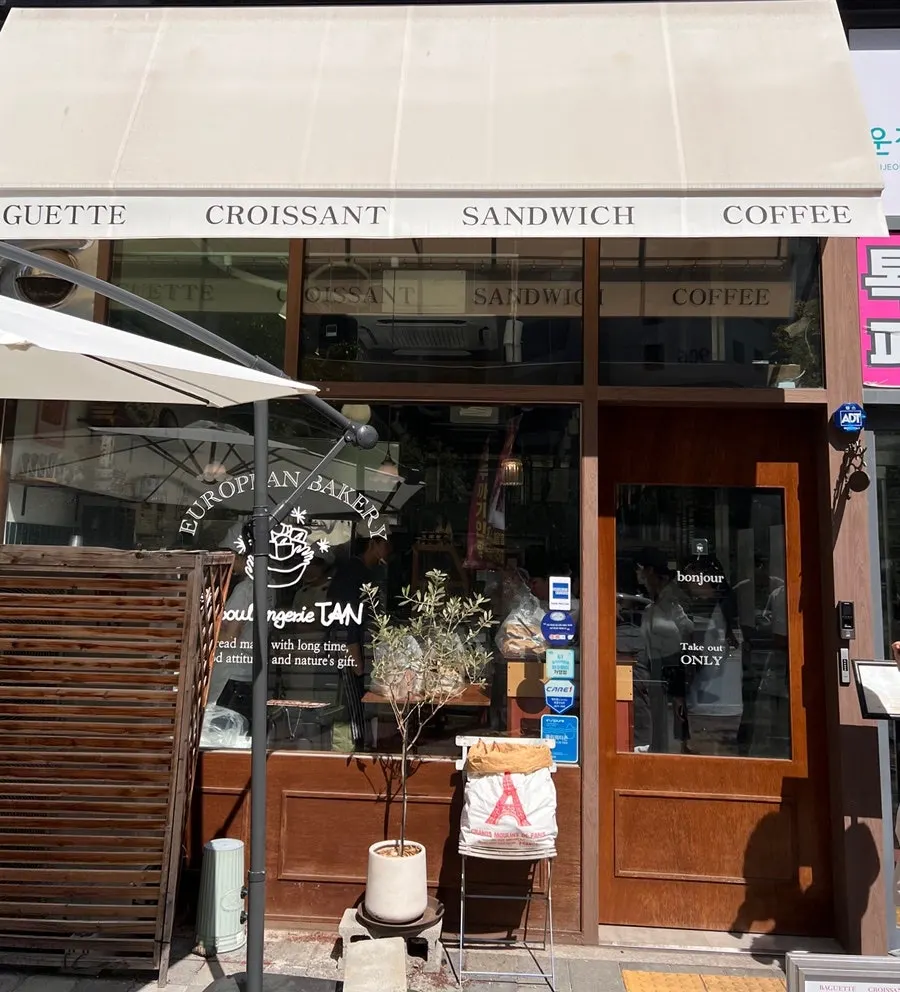 Wood-toned exterior of Boulangerie Tan Unjeong Main Branch on the 1st floor of Farm Tower