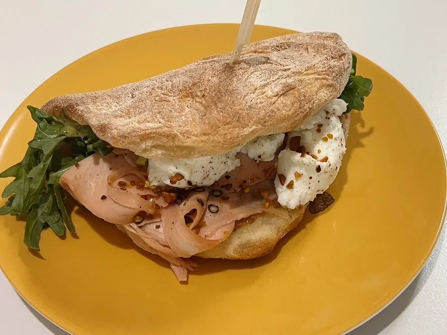 Cross-section of mortadella ricotta panuozzo with arugula