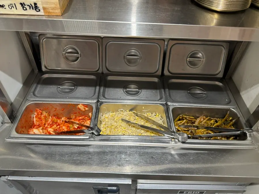Three self-serve side dishes: kimchi, bean sprouts, and pickled chili
