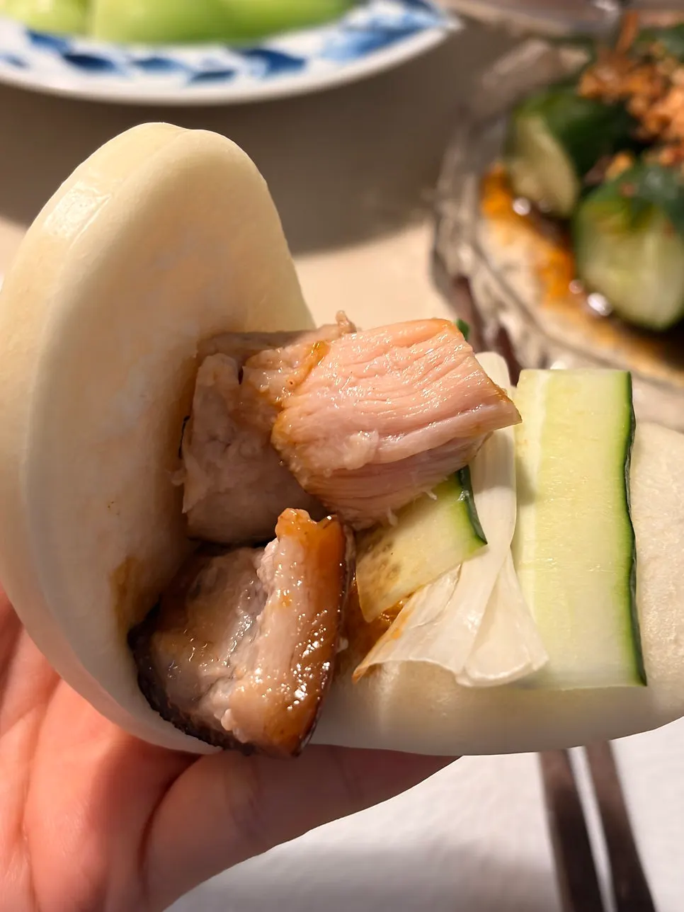 Wrapping dongpo-yuk with scallion and cucumber in a mantou bun