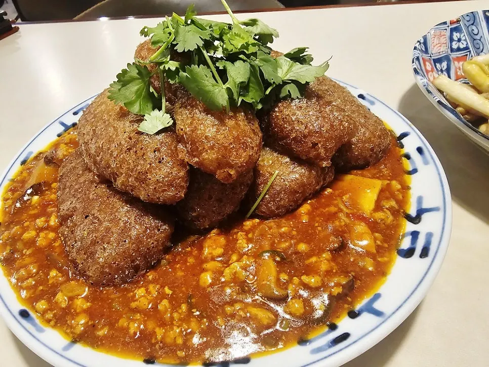 Mala sauce eggplant fritters topped with cilantro