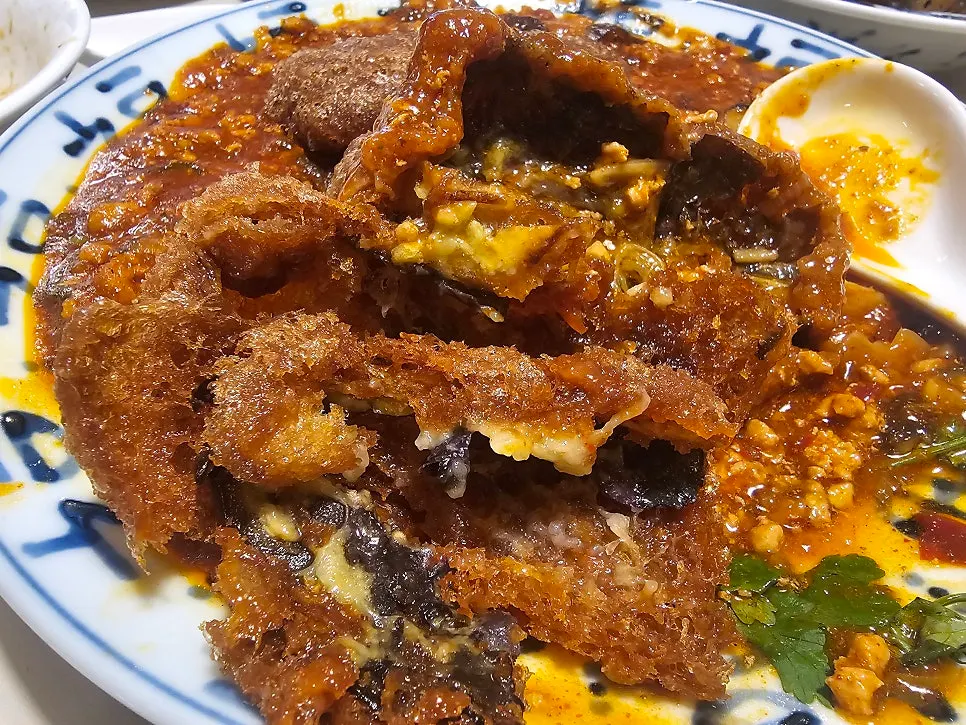 Cross-section of a mala sauce eggplant fritter showing the eggplant inside the batter
