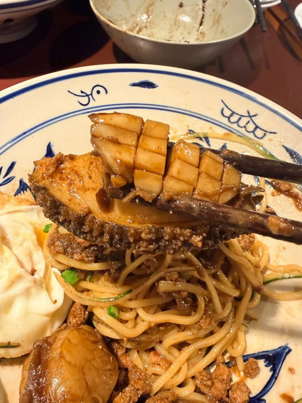 Abalone samseon-jjajangmyeon topped with a whole scored abalone