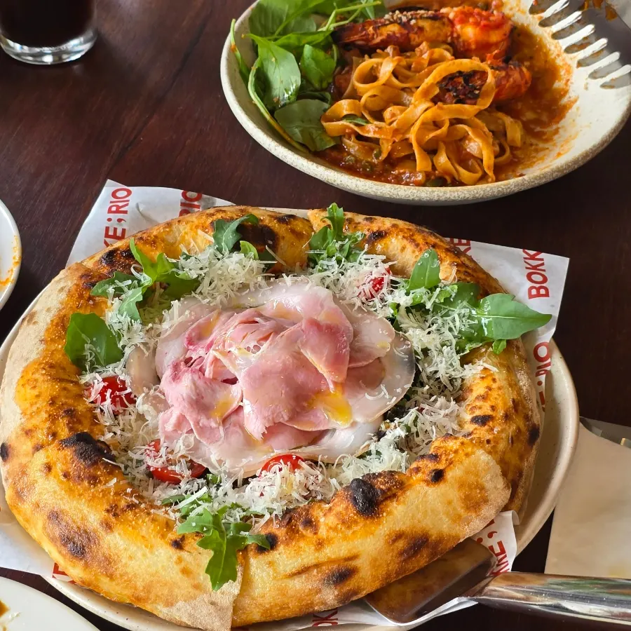 Rucola prosciutto pizza piled high with prosciutto