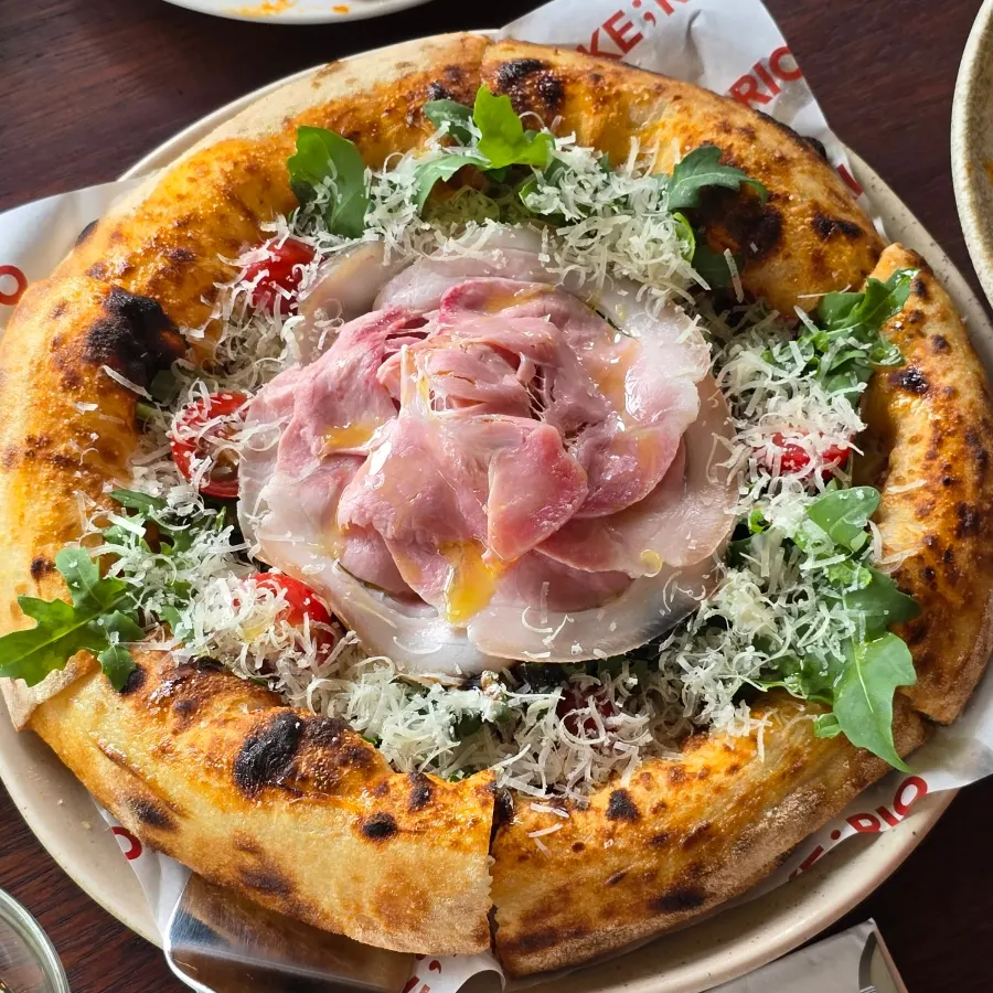 Close-up of fresh rucola on the prosciutto pizza