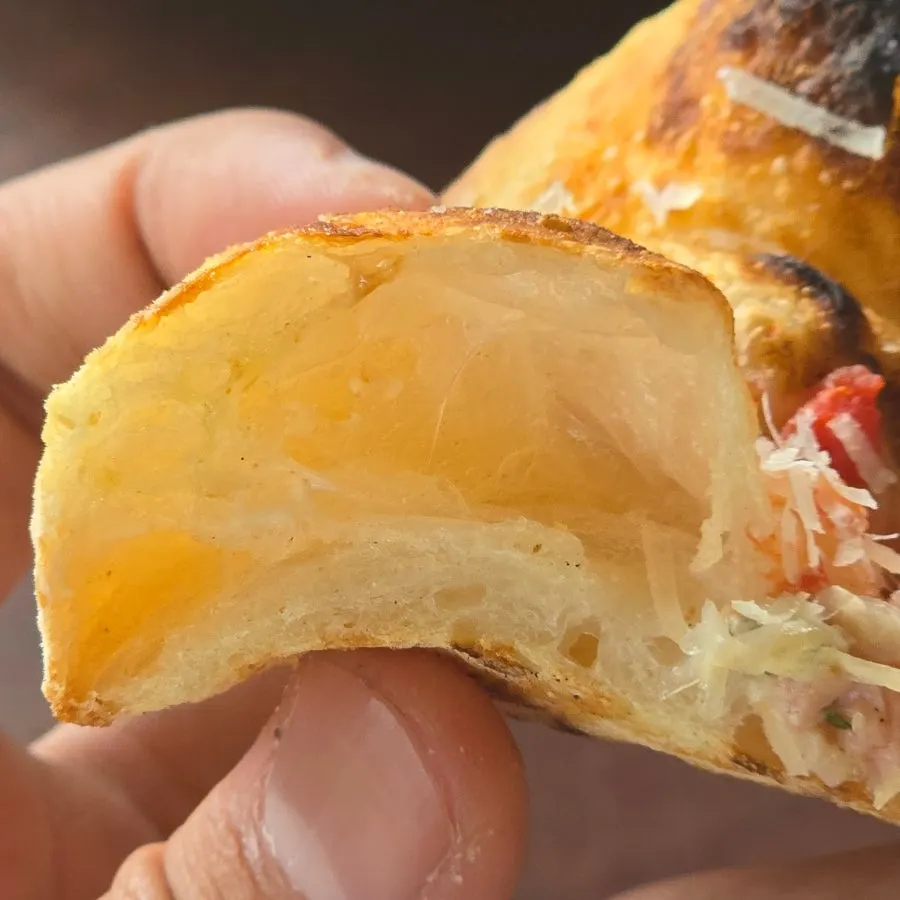 A slice of rucola prosciutto pizza served out