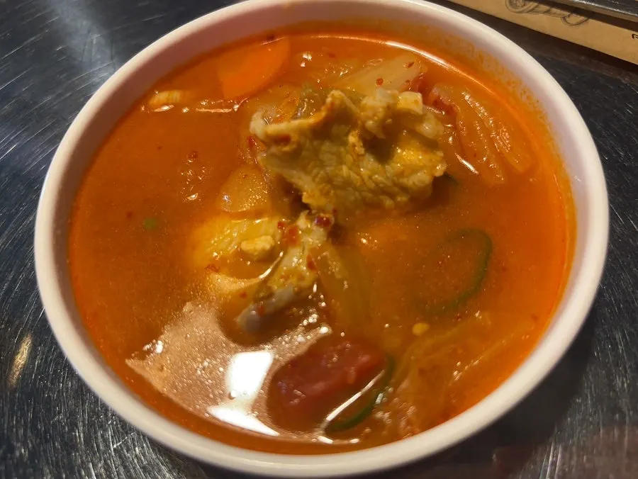 Kimchi jjigae served as a complimentary side with the curry