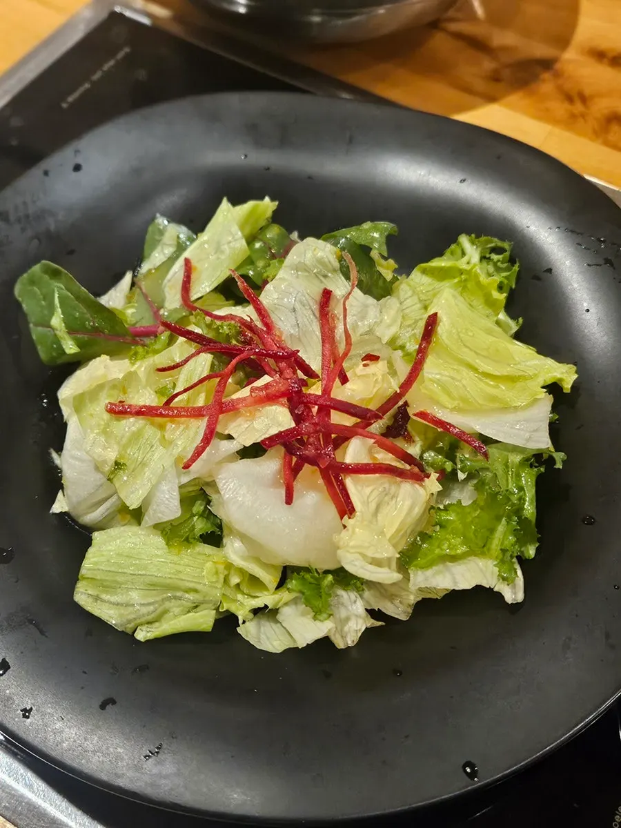 Spread of bibimbap ingredients and salad