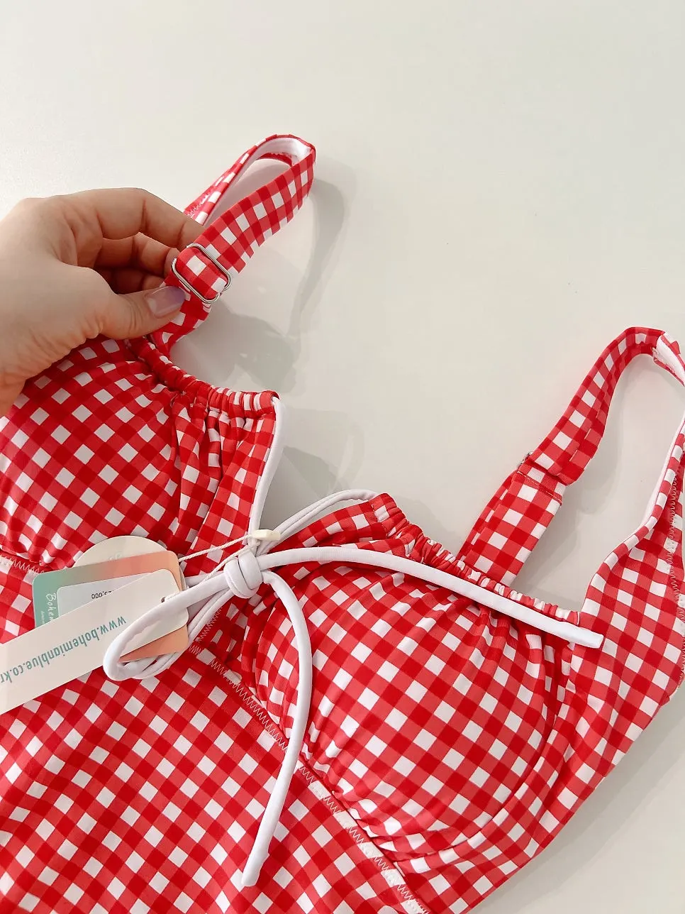Adjustable shoulder strap on the gingham one-piece swimsuit