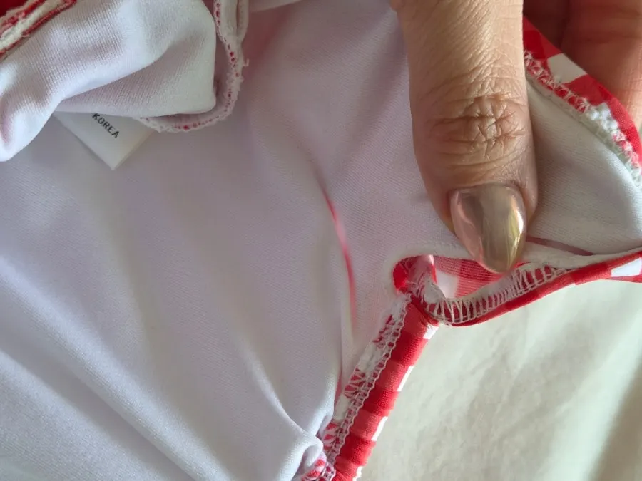 Shirring ribbon and fit-adjustment detail on the one-piece swimsuit